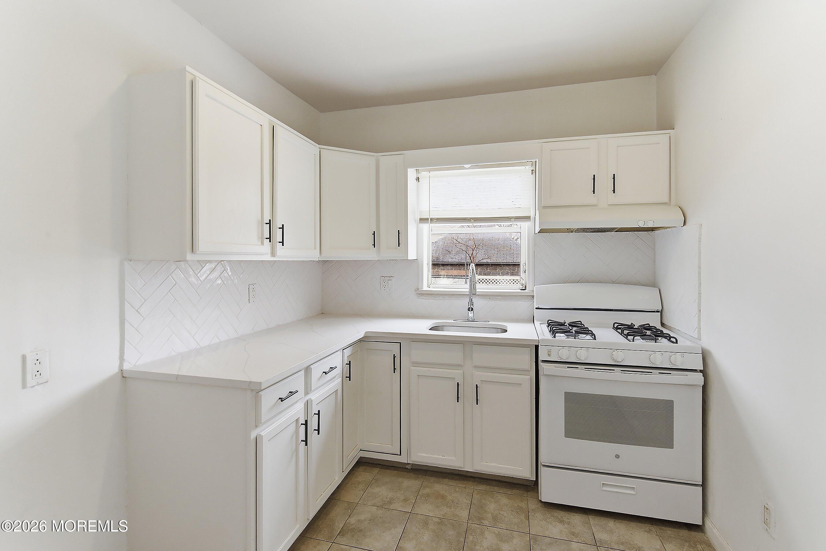 46 West 12th Street Linden, NJ 07036 - Photo 9 of 18 a kitchen with white cabinets and white appliances