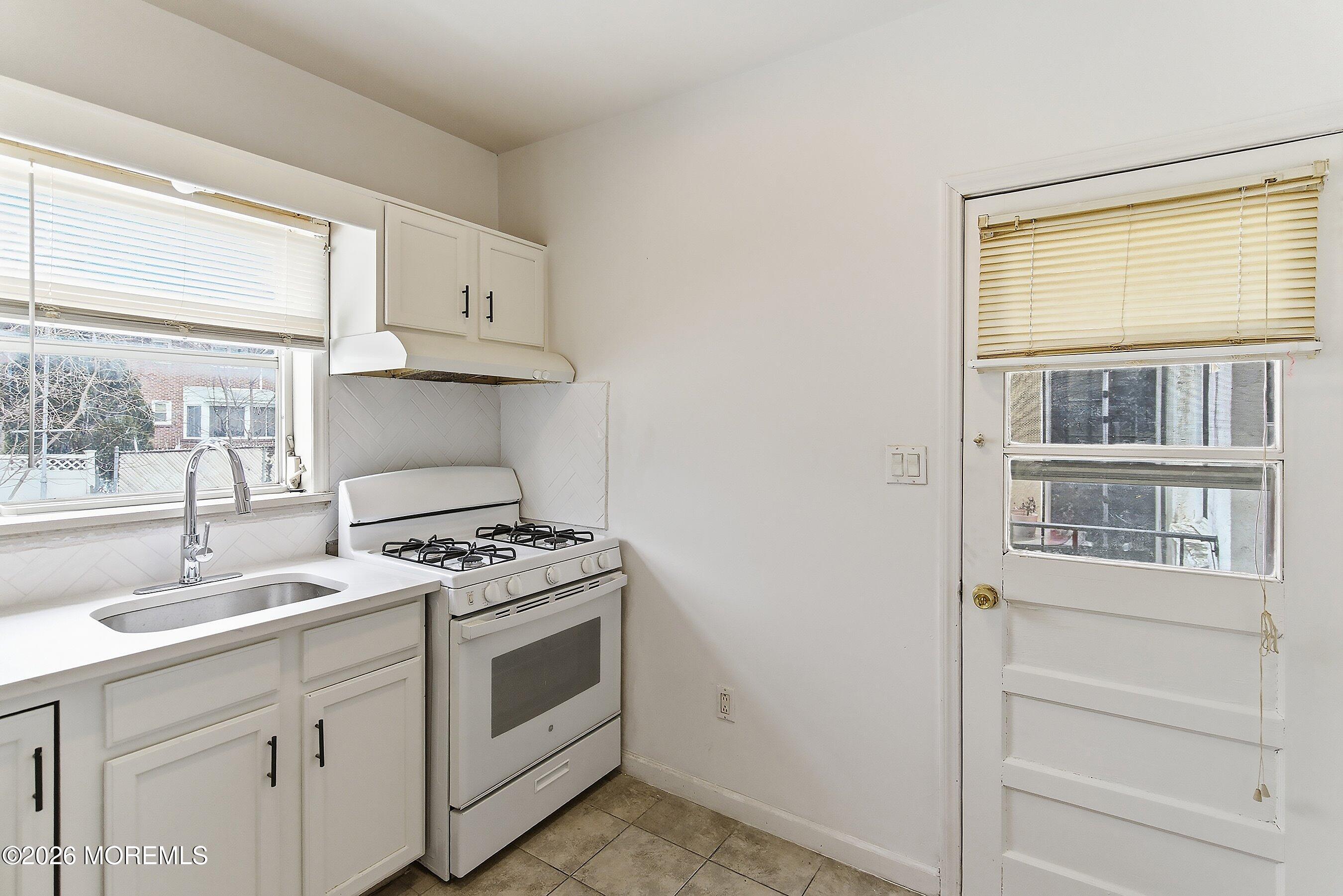46 West 12th Street Linden, NJ 07036 - Photo 10 of 18 a kitchen with white cabinets and a stove