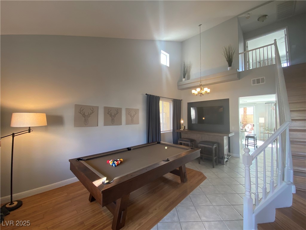 10637 Amblewood Avenue Las Vegas, NV 89144 - Photo 12 of 32 Playroom with pool table, high vaulted ceiling, light wood finished floors, and a chandelier