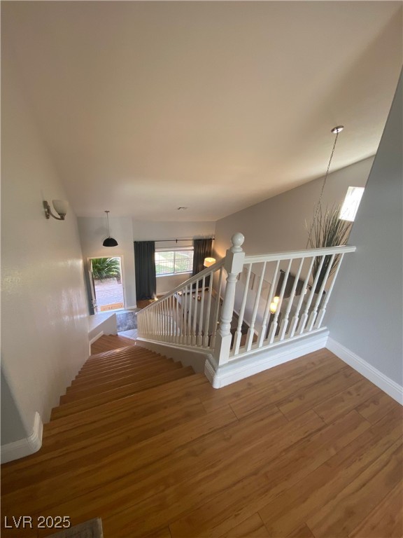 10637 Amblewood Avenue Las Vegas, NV 89144 - Photo 13 of 32 Stairs featuring wood finished floors and a chandelier