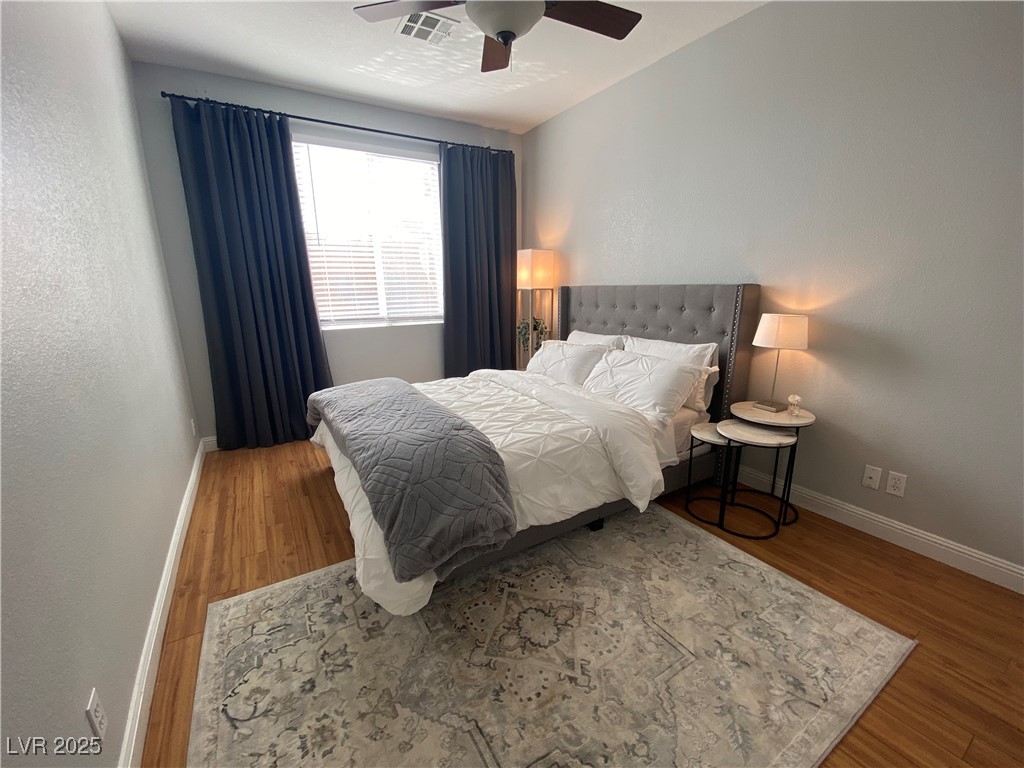10637 Amblewood Avenue Las Vegas, NV 89144 - Photo 28 of 32 Bedroom with wood finished floors, ceiling fan, and a textured wall