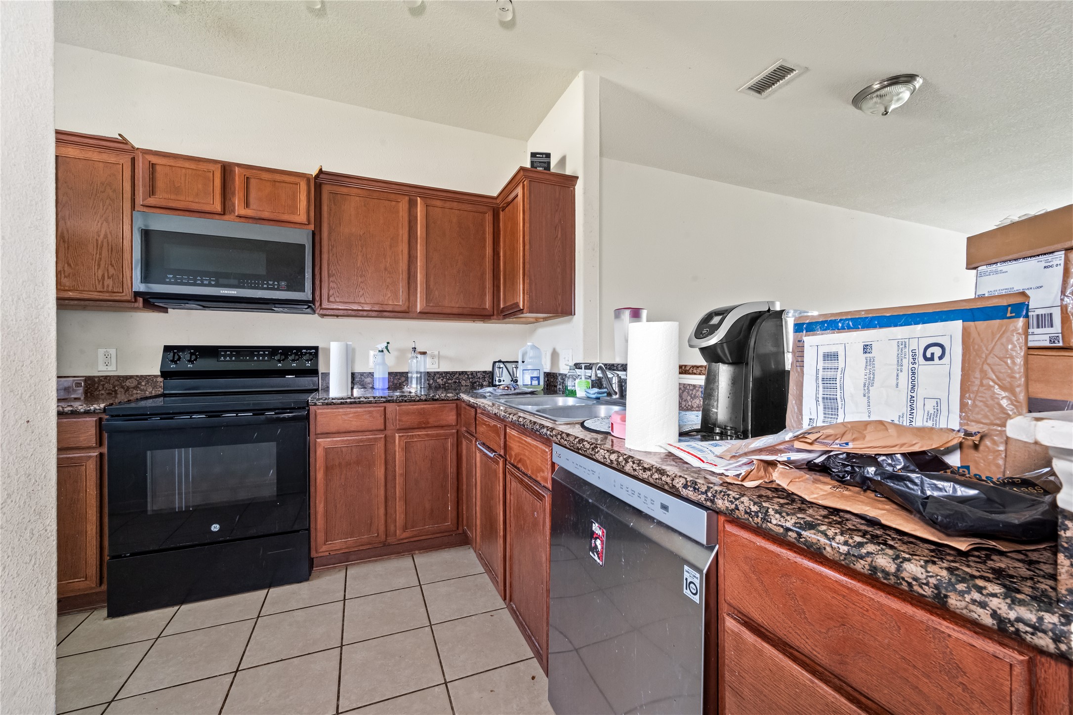 28832 San Bernard River Loop Spring, TX 77386 - Photo 13 of 50 a kitchen with stainless steel appliances granite countertop a stove top oven a sink dishwasher and a microwave oven on the blue kitchen countertops