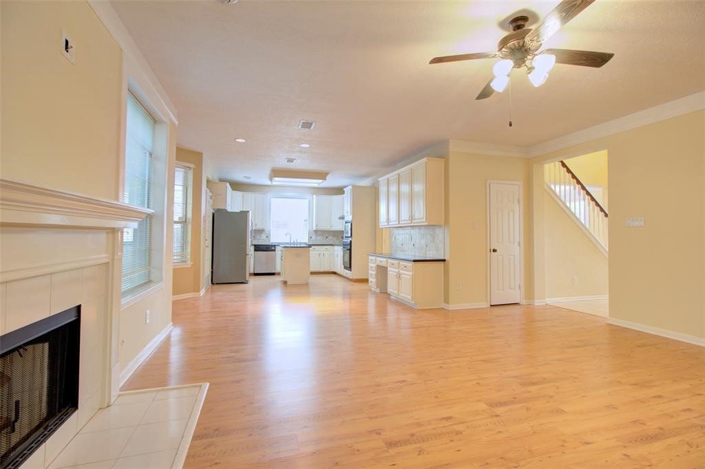 1226 Rabbs Crossing Sugar Land, TX 77479 - Photo 14 of 50 a view of an empty room and kitchen view with wooden floor