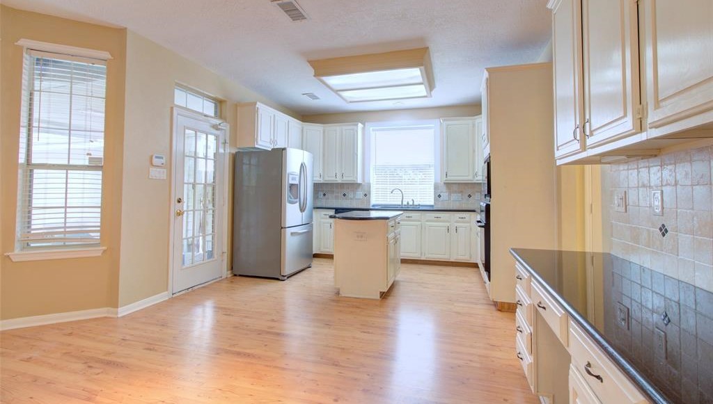 1226 Rabbs Crossing Sugar Land, TX 77479 - Photo 16 of 50 a kitchen with a refrigerator a sink and cabinets