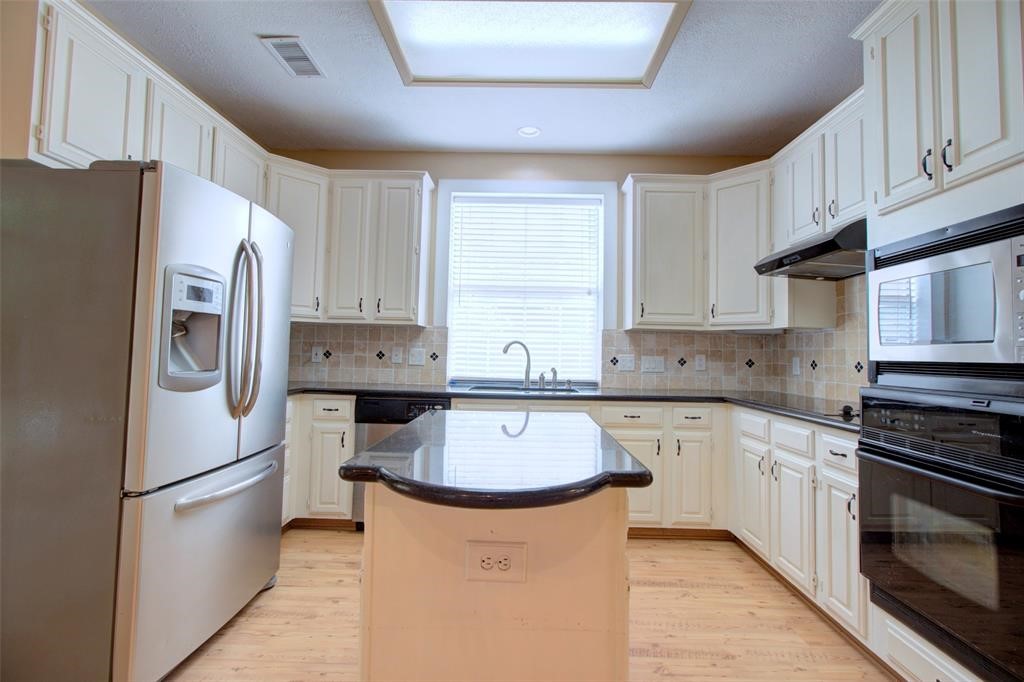 1226 Rabbs Crossing Sugar Land, TX 77479 - Photo 18 of 50 a kitchen with stainless steel appliances a refrigerator sink and cabinets