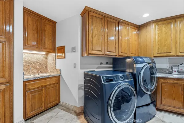 a utility room with lots of clutter and cabinets