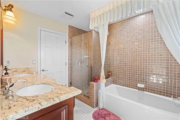 a large bathroom with a glass shower door and a sink