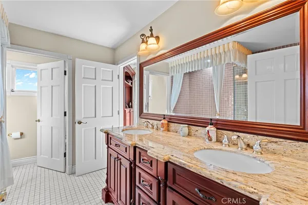 a bathroom with a granite countertop sink a toilet and a mirror