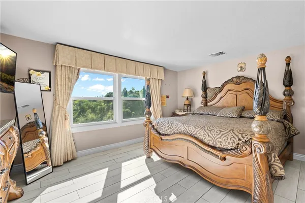 a bedroom with a bed and a large window