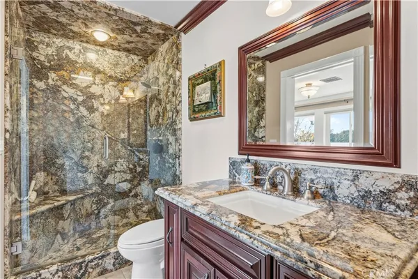 a view of a white house next to a yard with plants and large trees