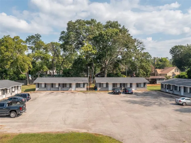 aerial view of house with outdoor seating and covered with trees