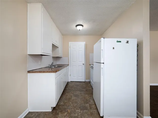 a kitchen with granite countertop a refrigerator and a stove