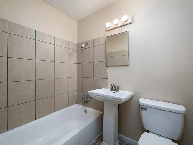 a bathroom with a sink a toilet and mirror