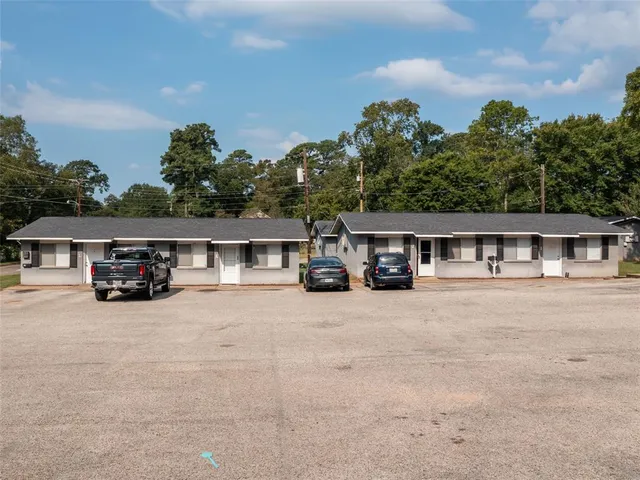an outdoor view of a house with cars parked