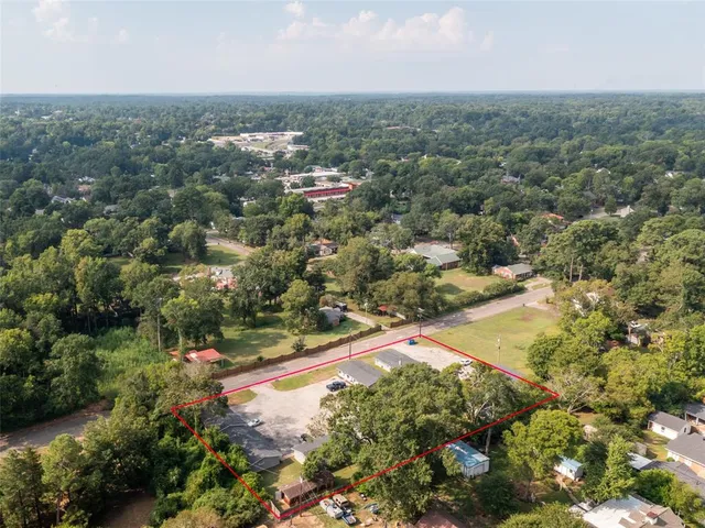 an aerial view of residential houses with outdoor space and trees
