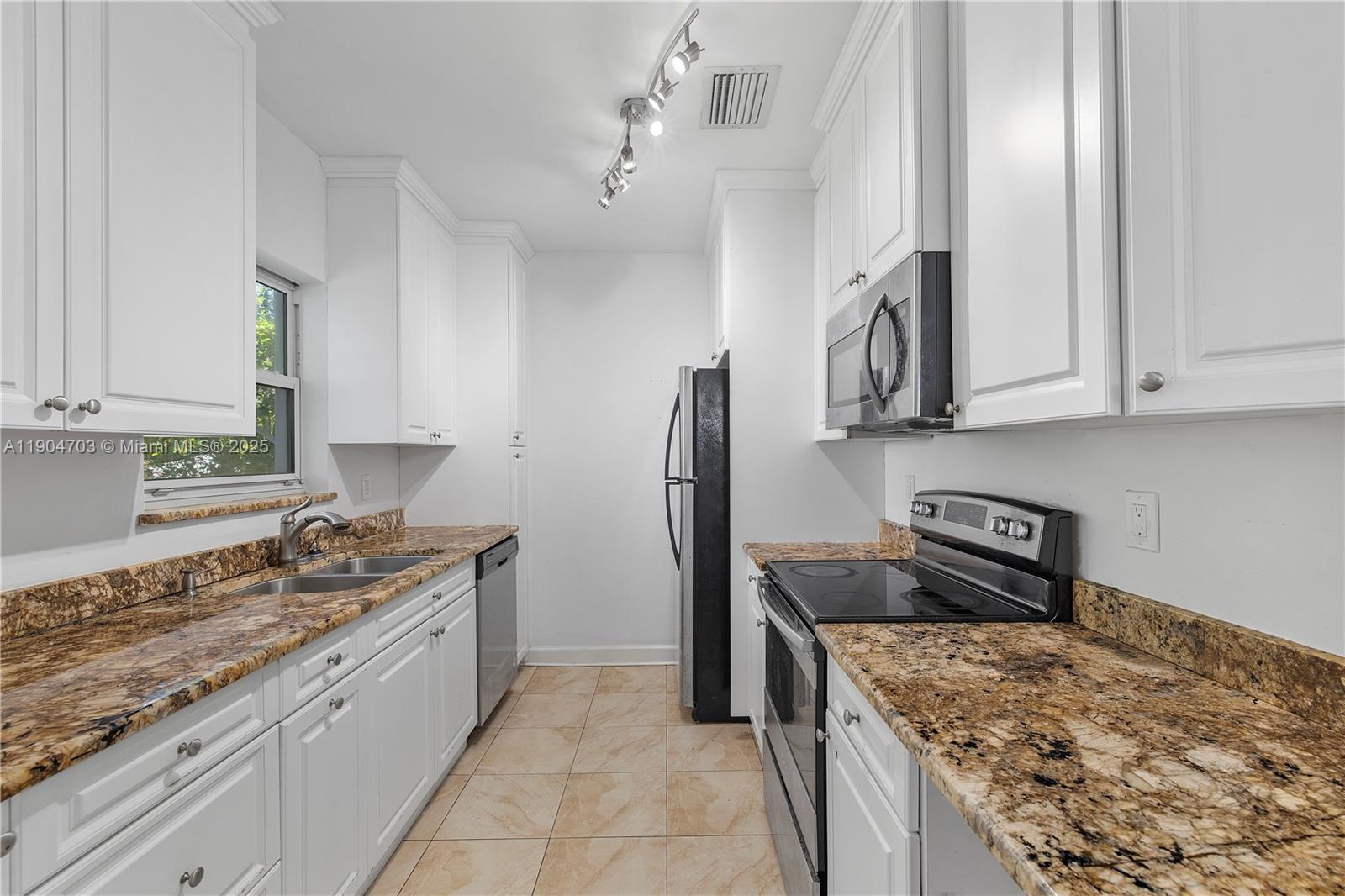 8826 Emerson Avenue Surfside, FL 33154 - Photo 11 of 25 a kitchen with stainless steel appliances granite countertop a sink stove and refrigerator