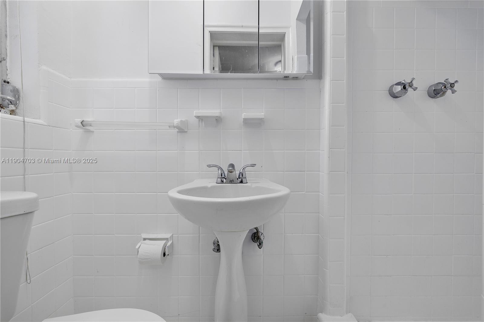 8826 Emerson Avenue Surfside, FL 33154 - Photo 16 of 25 a bathroom with a sink a toilet and shower