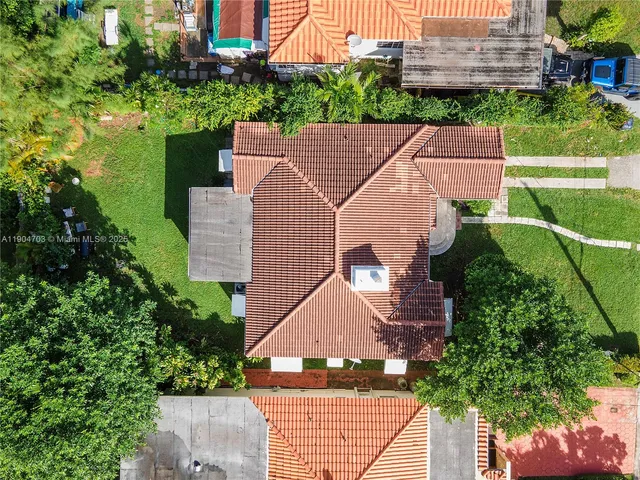 an aerial view of a house with a yard and potted plants