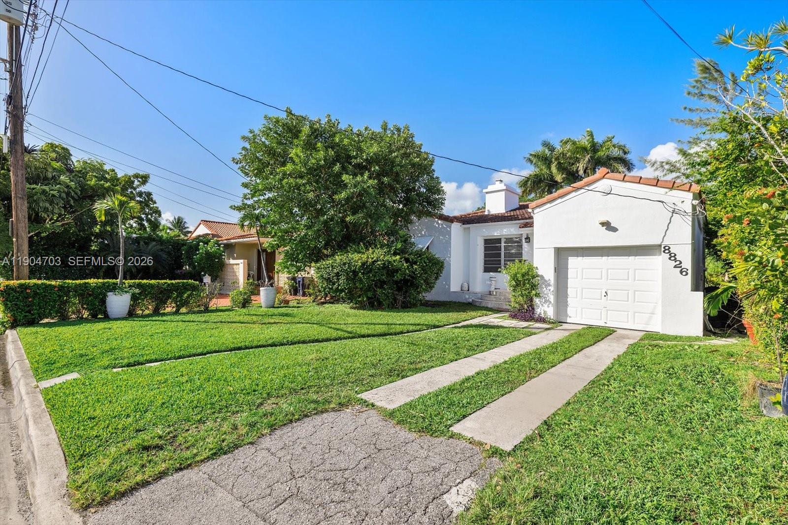 8826 Emerson Avenue Surfside, FL 33154 - Photo 2 of 25 a front view of a house with a yard and garage