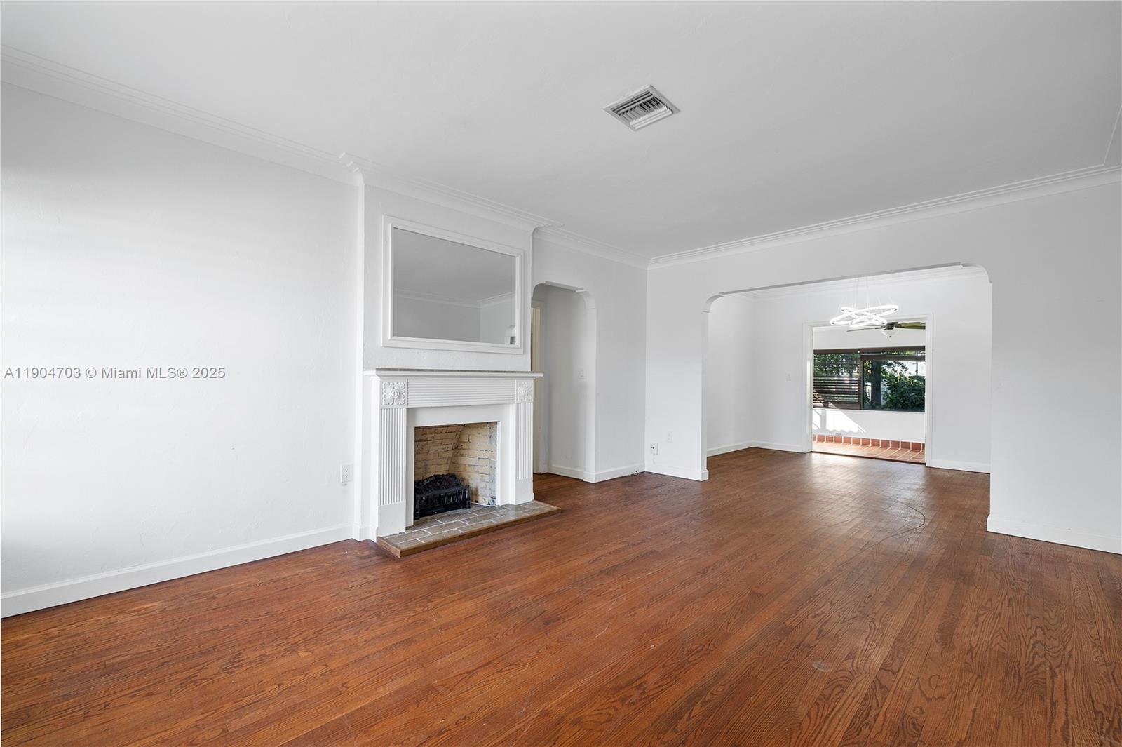 8826 Emerson Avenue Surfside, FL 33154 - Photo 5 of 25 a view of empty room with wooden floor and fireplace