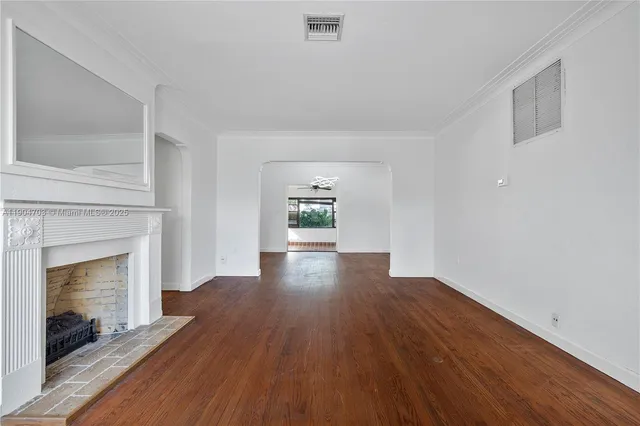 a view of empty room with wooden floor and fireplace