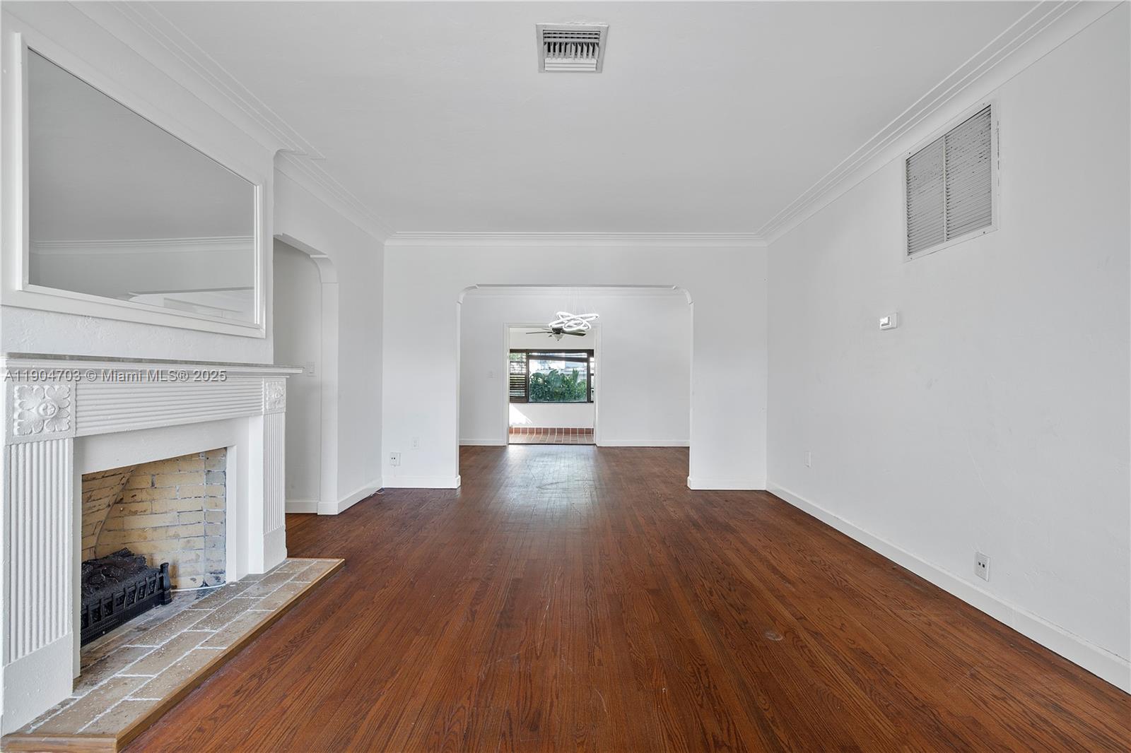 8826 Emerson Avenue Surfside, FL 33154 - Photo 6 of 25 a view of empty room with wooden floor and fireplace