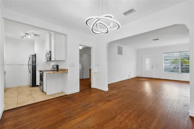 a view of empty room with wooden floor and window
