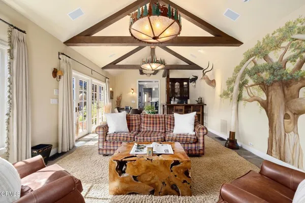 a living room with furniture a large window and a chandelier