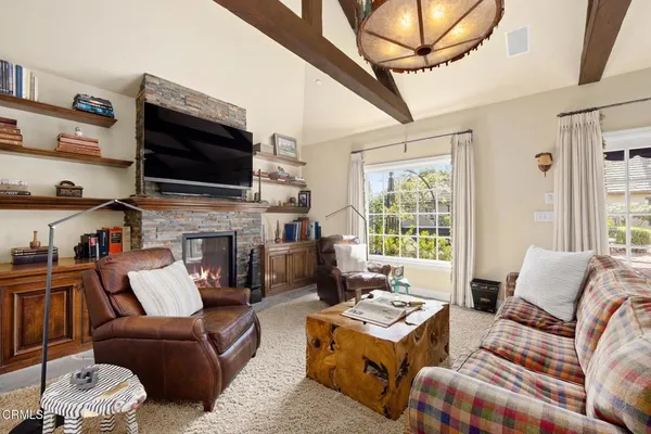 a living room with furniture a flat screen tv and a fireplace