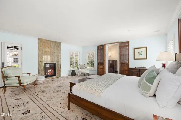 a large bedroom with a bed and wooden floor