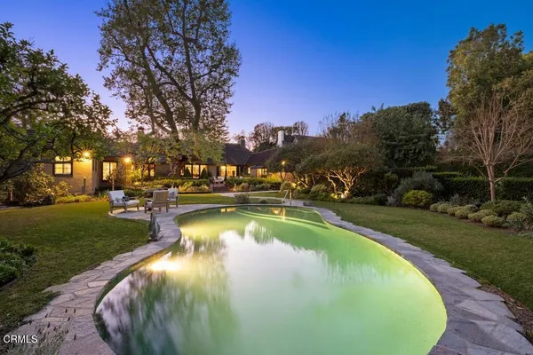 a view of a swimming pool with outdoor seating and green space