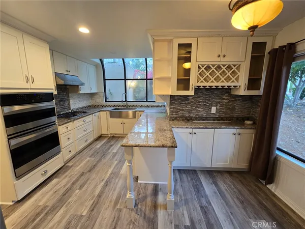 a kitchen with stainless steel appliances granite countertop a stove and cabinets