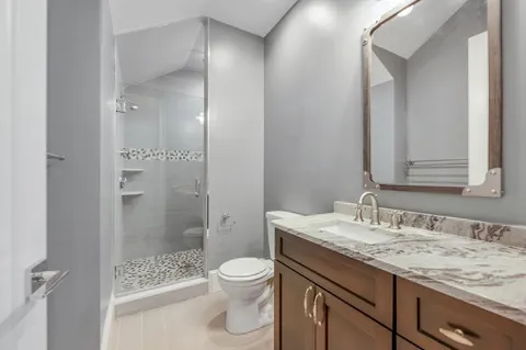 a bathroom with a granite countertop sink toilet and shower