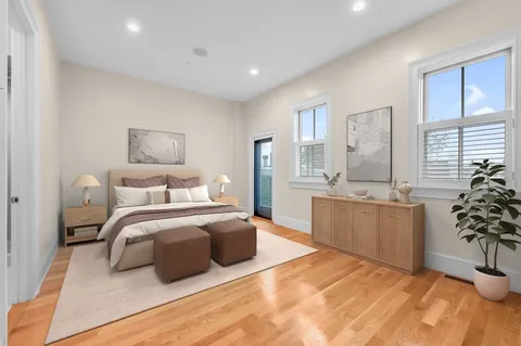 a bedroom with a large bed and a potted plant