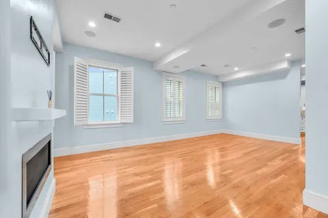 a view of an empty room with a fireplace and a window