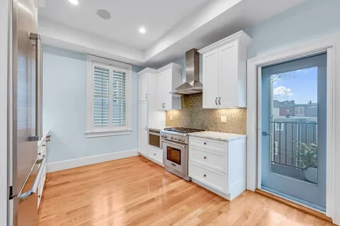 a kitchen with stainless steel appliances granite countertop a stove a sink and a refrigerator