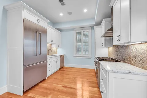a kitchen with white cabinets and stainless steel appliances