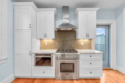 a kitchen with a stove and white cabinets