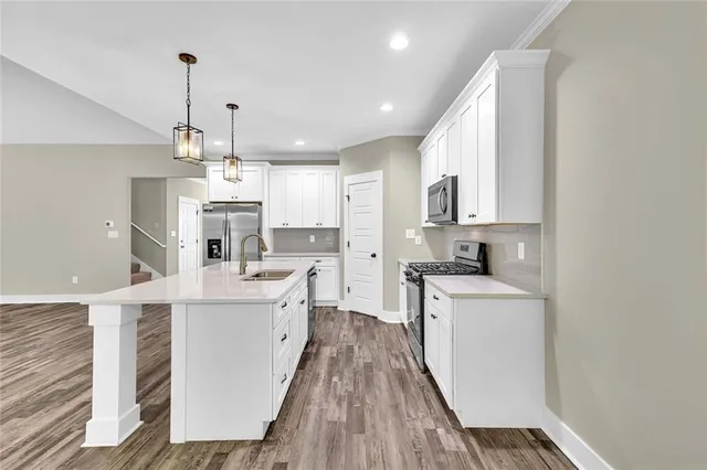 a kitchen with white cabinets appliances and sink