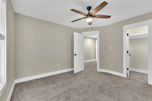 an empty room with window and ceiling fan