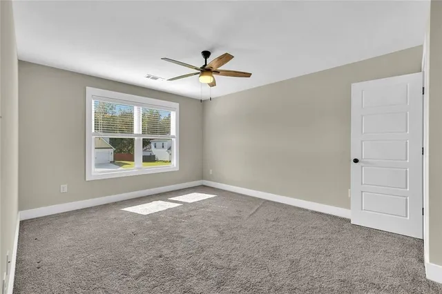 a view of a livingroom with a ceiling fan & entryway