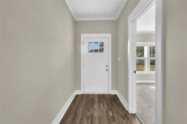 a view of a hallway with wooden floor and closet