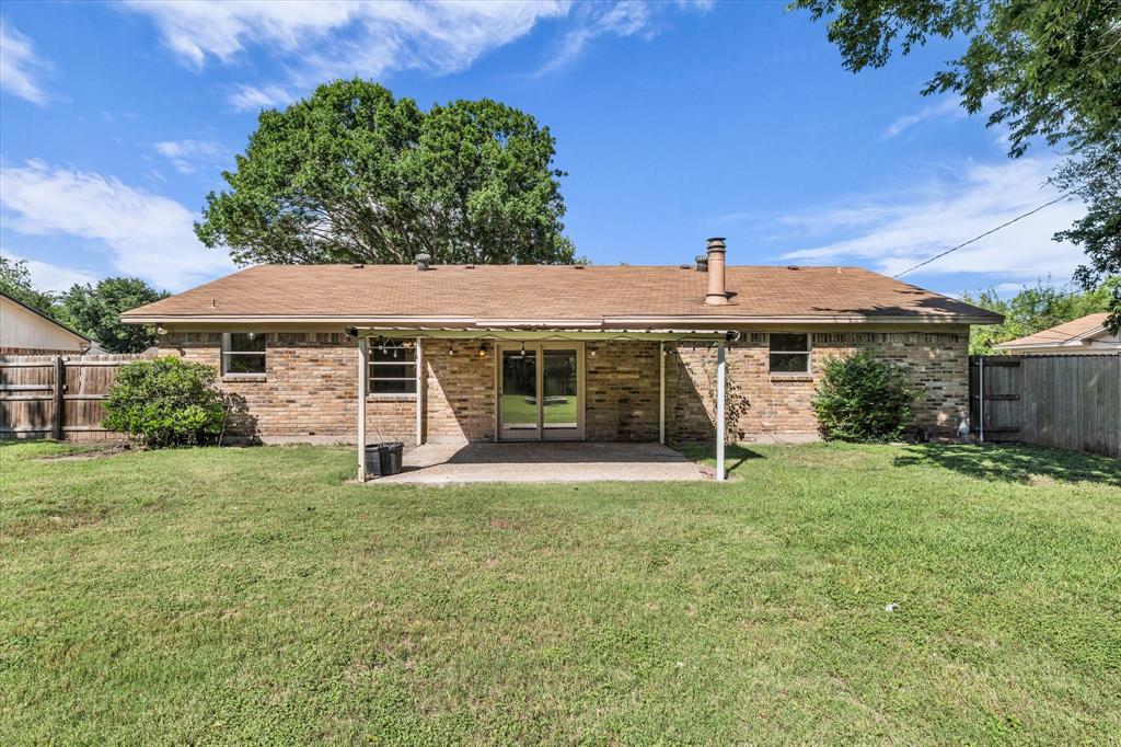 141 Travis Lane Hewitt, TX 76643 - Photo 25 of 31 Expansive backyard featuring a covered patio, brick exterior, and a privacy fence