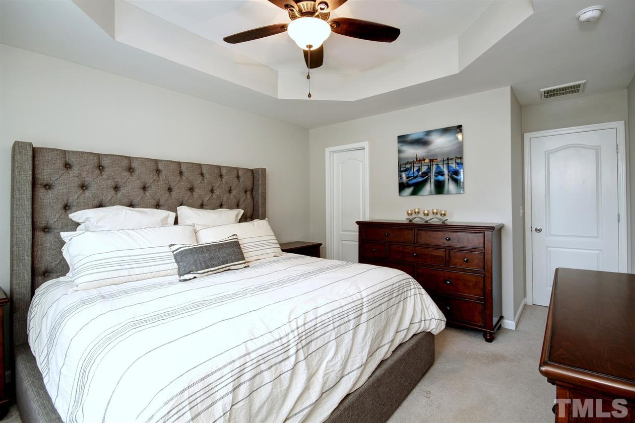 927 Ileagnes Road Raleigh, NC 27603 - Photo 13 of 26 a bedroom with bed and a chandelier