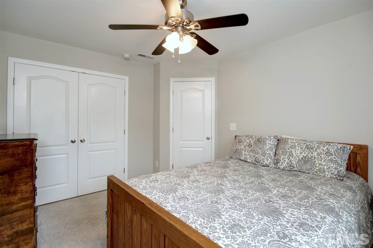 927 Ileagnes Road Raleigh, NC 27603 - Photo 16 of 26 a bedroom with a bed and a chandelier