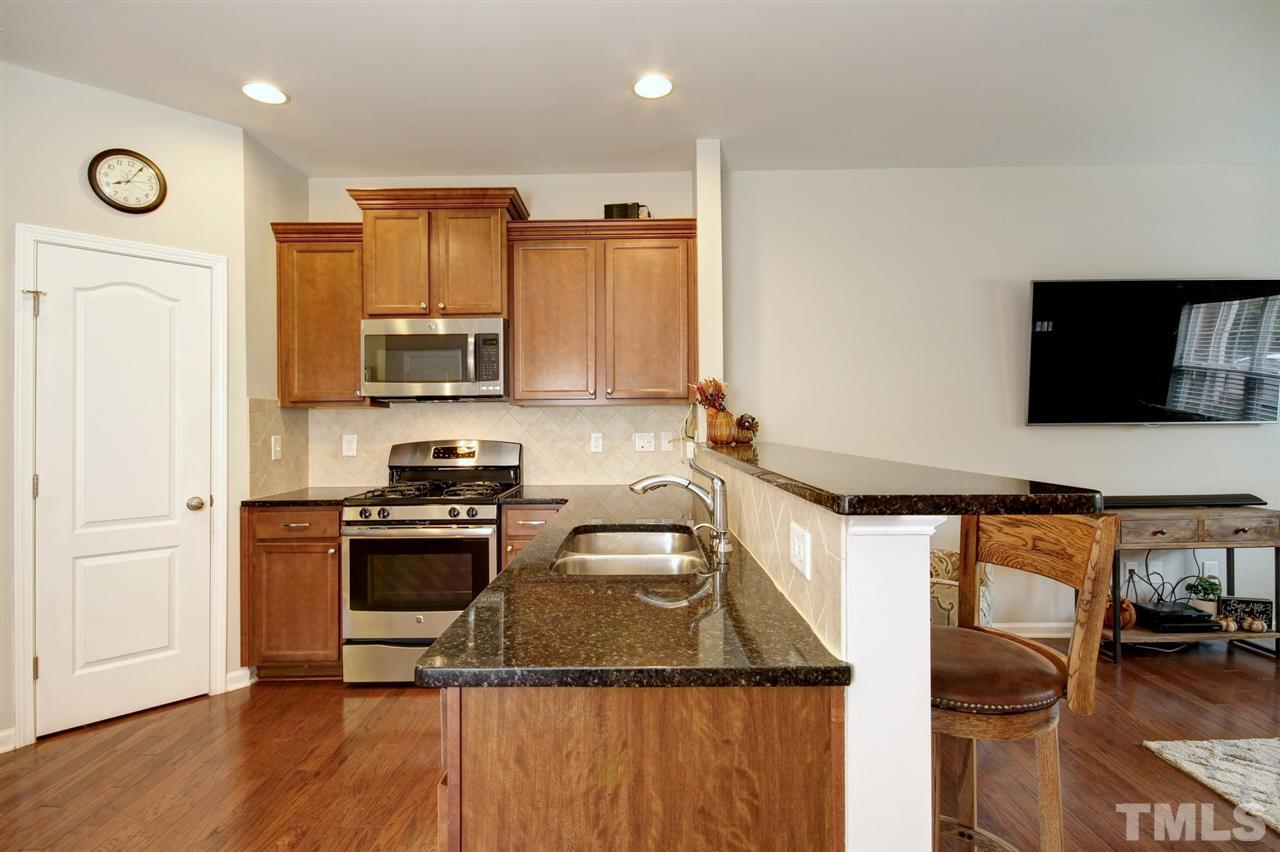 927 Ileagnes Road Raleigh, NC 27603 - Photo 8 of 26 a kitchen with stainless steel appliances granite countertop a stove a sink and a microwave