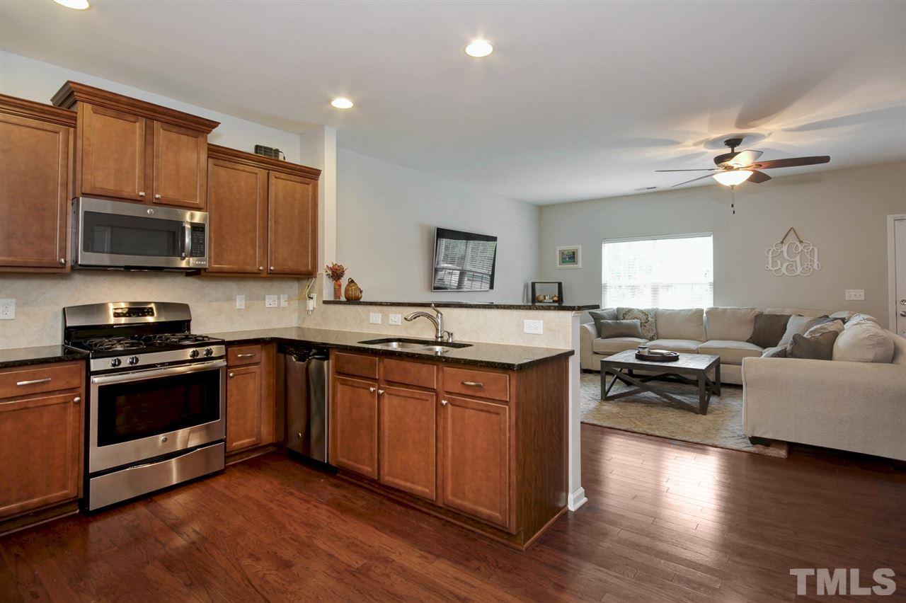 927 Ileagnes Road Raleigh, NC 27603 - Photo 9 of 26 a kitchen with stainless steel appliances granite countertop a stove a sink dishwasher and a microwave oven with wooden floor