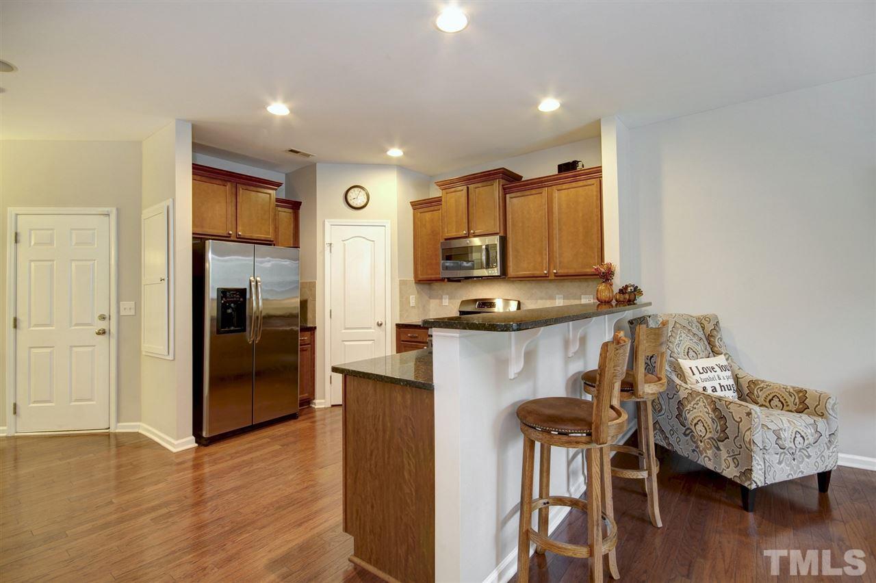 927 Ileagnes Road Raleigh, NC 27603 - Photo 10 of 26 a kitchen with stainless steel appliances granite countertop a refrigerator a stove and a wooden floors
