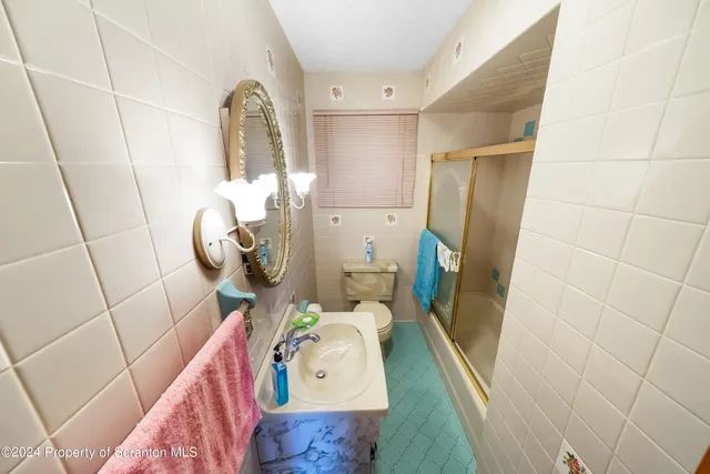 a bathroom with a sink and mirror with bathtub