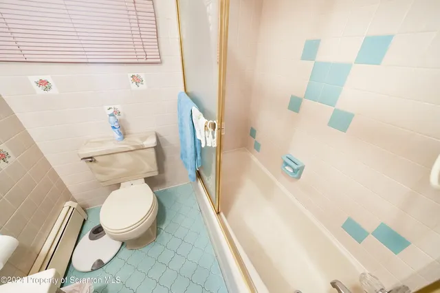 a white toilet sitting next to a bath tub